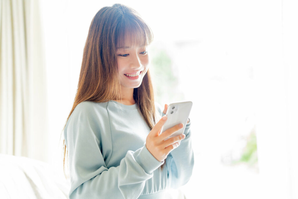スマホを見て安心する女性