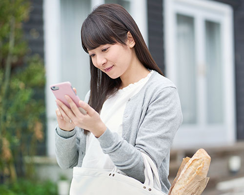 外でスマホを確認する女性