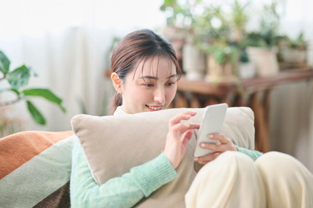 スマホを見て安心する女性